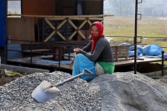 Una giovane donna nepalese, appartenente alla casta dei "Sudra" (servi ed artigiani), si prende una pausa nel suo duro lavoro di manovalanza svolto accanto ad una casa in costruzione dopo il terremoto, Patan, Nepal 2018