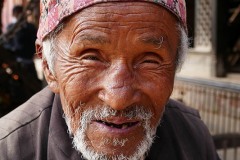 Un anziano uomo nepalese dell'etnia Gurung mi sorride divertito mentre lo ritraggo con la mia macchina fotografica, villaggio di Gorkha, Nepal 2018.