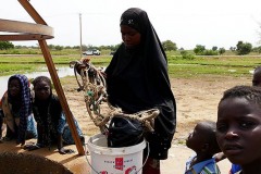 Donna nomade Peul tira su l'acqua a mano dal pozzo con una corda alla cui estremità è agganciato un secchio rudimentale ricavato dalla camera d'aria di un pneumatico: il suo è un gesto antico, che ripete ogni giorno con notevole fatica, vicinanze del Villaggio Bagga Tabla, Niger 2019
