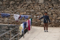 Un bambino appartenente all'etnia degli Sherpa gioca da solo con un cordoncino annodato con diversi fili colorati: basta poco per divertirsi, a volte solo un pochino di fantasia. Villaggio di Panauti, Nepal 2018.