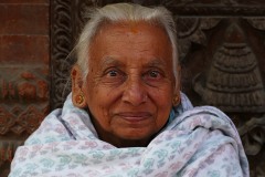 Lo sguardo intenso di questa anziana donna Thakali rappresenta compiutamente lo spirito del Popolo nepalese: la tolleranza che pervade ogni momento della vita degli abitanti del Nepal (e che ha contribuito a far convivere pacificamente etnie e popolazioni diverse, oltre a religioni di origini completamente differenti), l'armonia che ha consentito di mischiare divinità Buddhiste ed Hinduiste con lo sciamanesimo, l'ospitalità sacra ed il rispetto che sono a fondamento della cultura di questo Paese affascinante. La visione del mondo dei nepalesi è dominata dalle preghiere e dalla liturgia, oltre che dalla consapevolezza che gli Dei non siano remoti concetti atratti, ma esseri viventi e presenti che possono influenzare le vicende umane in modo diretto. L'elemento divino è presente in ogni cosa, così come gli spiriti e le Divinità credono siano presenti negli alberi, nei passi montani, sulle vette montuose ed alla confluenza dei fiumi. Nepal 2018.