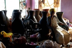 La sala espositiva di un piccolo laboratorio artigiano di vasellame, la donna seduta e sorridente è la padrona che si chiama Mieke, Provincia del Limpopo, Sud Africa 2012
