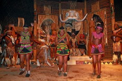 Le giovani donne Zulu con i tipici vestiti impreziositi dalle perline multicolori, muovono passi di danza "Ukusina", danza legata alla cerimonia "Umemulo" che celebra il passaggio della giovane donna Zulu alla maggiore età ed alla possibilità di sposarsi e di procreare. Il rituale prevede anche la macellazione di una mucca che viene offerta a tutti gli abitanti del villaggio che, da parte loro donano denaro e benedizioni alla giovane donna. Villaggio di Shakaland, Provincia del KwaZulu-Natal, Sud africa 2012