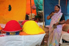 Nel mercato di Saundatti una donna Hindu che vende polveri colorate sbadiglia annoiata nelle prime ore del mattino, quando i clienti ancora scarseggiano. Regione del Karnataka, India 2015.