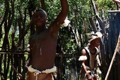 Un giovane Swazi alza trionfalmente il proprio scudo, mentre imbraccia la sua lancia, nel gesto di saluto, Villaggio di Ludzidzini, eSwatini (in precedenza denominato Swaziland) 2012.