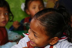 Questa bambina nepalese appartenente all'etnia Chhetri ed alla casta Kshatriya (individuata tra i soldati e gli amministratori dello stato) scherza con il suo vicino di banco durante il pranzo a base di riso, Shree Bal Bikosh Basic School, quartiere di Cheetrapati, Kathmandu, Nepal 2018.