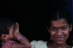 Lo sguardo magnetico di questa ragazza è incantevole: il suo nome è Dharini e la sua timida sorellina si nasconde con le manine il volto.Villaggio di Belur, regione del Karnataka, India 2015.
