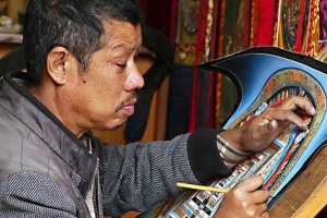 Il termine Mandala in sanscrito indica un oggetto sacro di forma rotonda o un disco (in quest'ultimo caso in special modo se riferito al Sole od alla Luna): qui un'artista sta realizzando a mano libera uno di questi capolavori nella sua bottega di Kathmandu. Nei testi tantrici questo termine indica appunto uno spazio sacro, molto spesso circolare, ma anche triangolare o quadrangolare, in cui le Divinità sono invitate ad entrare per mezzo di precisi mantra. Nella cultura Buddhista esso indica dei diagrammi geometrici elaborati con diversi materiali ed utilizzati per scopi rituali o meditativi (non deve essere considerato un mero "disegno", per quanto rappresentativo o simbolico, ma è quel "luogo" creato da colui che medita, all'interno del quale contempla la Divinità che vi sono entrate a seguito della sua invocazione. Il Mandala viene ad indicare per i Buddhisti la rappresentazione dell'Universo e la sua elaborazione è una pratica rituale che prevede anche di disegnarlo a terra, allo scopo rituale di consacrazione, iniziazione o protezione. Esso può rappresentare anche la residenza di una Divinità principale inserita al centro della rappresentazione e circondata da Divinità sussidiarie. Nepal 2018.