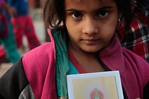 Una bambina di strada nel punto d'incontro tra Durbar Square e Basantapur Square, accanto al Kumari Bahal (la residenza della bambina prescelta come Dea vivente della città di Kathmandu e simbolo della Divinità femminile Hindu), propone ai passanti la riproduzione su carta del Dio Ganesh: risulta evidente il lacerante contrasto tra le condizioni di vita di questa bambina e della Kumari...Nepal 2018