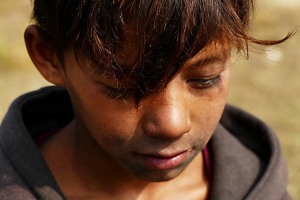 Questo bimbo nepalese di strada è riuscito solamente una volta ad incrociare il mio sguardo e l'obiettivo della mia macchina fotografica: nei diversi scatti in cui lui era protagonista insieme al suo amico e compagno di vita il suo sguardo era diretto a terra oppure era assente. Come se il dolore e l'angoscia che attanagliano il suo giovane animo siano talmente pesanti da schiacciarlo. Devo confessare che sono stato colpito dalla tristezza che traspare evidente dal suo volto e dalle sue espressioni. Come se avessi ricevuto un pugno in pieno stomaco. Le lacrime ad un certo punto sono scese, irrefrenabili, da sole e non sono riuscito a trattenerle. Lungolago di Phewa Tal, Pokhara, Nepal 2018.