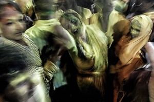 Una devota in trance durante la processione dei pellegrini che portano la statua della Dea Yallamma all'interno del Tempio alla stessa dedicato: un flusso infinito dove la polvere sottile di curcuma e kum kum colorano il corpo e l'anima, un disordine delirante, un'esplosione di colori, un ritmo cadenzato dalla forza impetuosa e possente del mantra "Udho Udho", il saluto propiziatorio diretto alla Dea dei diversi, dei dimenticati, degli individui desiderosi di uscire dal cono d'ombra in cui sono costretti, di coloro che intendono rivendicare l'attenzione della società classista. Dintorni del Tempio dedicato alla Dea Yallamma, Villaggio di Saundatti, Regione del Karnataka, India 2015.