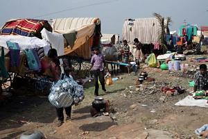 Uno scorcio dell'accampamento nelle adiacenze del villaggio di Saundatti che ospita oltre 100.000 pellegrini in occasione delle festività in onore della Dea Yallamma: i carri allineati con accanto i buoi od i cavalli che ruminano e si riposano dopo l'estenuante viaggio, fanno da cornice alla vita quotidiana dei fedeli che cucinano, mangiano, dormono in questi spazi comuni. Regione del Karnataka, India 2015.