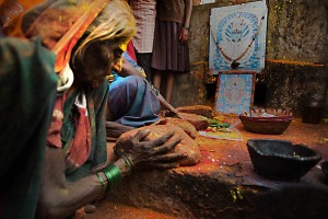 Donna sciamano (sacerdotessa devota alla Dea Yallamma) di nome Aparajita pratica l'antica tecnica esoterica della lettura del futuro attraverso lo studio delle pietre. Dintorni del Tempio dedicato alla Dea Yallamma, villaggio di Saundatti, Regione del Karnataka, India 2015.
