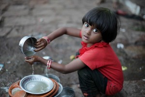 Una bambina Hindu di nome Bala lava i piatti nell'accampamento dove risiede temporaneamente con la sua famiglia durante il Renuka Yallamma Jatra, la grande Festa dedicata alla Dea Yallamma. Dintorni del villaggio di Saundatti, Regione del Karnataka, India 2015.