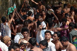 Il disordine delirante nel reparto destinato agli uomini per il bagno sacro e purificatore: qui vi è una sola doccia e ci si accalca in attesa del proprio turno. Dintorni del villaggio di Saundatti, Regione del Karnataka, India 2015.