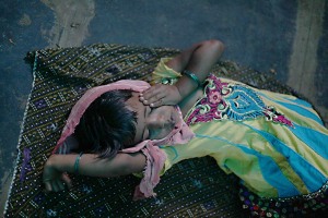 Una bambina è crollata per la stanchezza dovuta al lungo viaggio per giungere con la sua famiglia nel villaggio di Saundatti, in occasione dei festeggiamenti in onore3 della Dea Yallamma: dorme su un telo disteso a terra e indossa i vestiti della festa. Il suo nome è Cauvery e viene dalla Regione dell'Andhra Pradesh. India 2015.