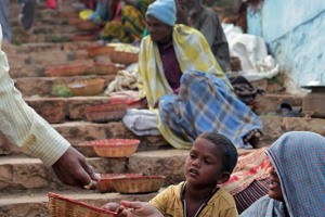 Lungo questa scalinata che conduce ad un sentiero in direzione del Tempio dedicato alla Dea Yallamma, decine di "Intoccabili" sono seduti sui gradini in attesa di qualche offerta da parte dei pellegrini presenti al Renuka Yallamma Jatra. I Dalit, meglio conosciuti come Intoccabili (la tradizione narra che essi, essendo destinati ad attività considerate impure come la conciature delle pelli animali, le pulizie delle fognature e delle latrine, la manipolazioni dei cadaveri, non possono essere toccati perchè impuri), vanno evitati, emarginati, discriminati. In India la popolazione è suddivisa sulla base di un antichissimo schema gerarchico sociale su base ereditaria che influenza ovviamente gli equilibri di potere, i rapporti economici, il mercato del lavoro ed i diritti (che non sono uguali per tutti, anzi, per i fuoricasta non esistono). Ciascuna casta viene identificata attraverso un colore specifico: il bianco, considerato simbolo di purezza, corrisponde alla casta dei sacerdoti; il rosso, considerato il colore del fuoco e del sangue, viene associato ai guerrieri ed ai nobili; il giallo-bronzo corrisponde ai mercanti, agli artigiani ed ai commercianti; il nero viene riservato ai servitori che svolgono attività faticose ed umili per conto degli altri tre gruppi. I Dalit non posseggono neppure un colore identificativo. Villaggio di Saundatti, Regione del Karnataka, India 2015.