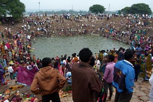 La vista panoramica dell'enorme piscina con gradinate degradanti, alimentata dal Saundatti Lake dove i pellegrini si bagnano, lavano le vesti, abbandonano le cose vecchie, lasciano le offerte alla Divinità. Dintorni del villaggio di Saundatti, Regione del Karnataka, India 2015.