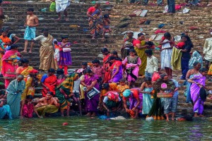 Sulle gradinate degradanti che permettono l'accesso all'enorme piscina alimentata dal lago di Saundatti, i pellegrini (prevalentemente donne) si bagnano mediante le piccole anfore d'argento con cui raccolgono l'acqua da versare sui loro corpi, lavano le vesti, lasciano offerte alla Dea Yallamma, abbandonano le loro cose vecchie. Colori di ogni gradazione e di diverse tonalità riempiono il mio sguardo come se stessi ammirando una tela sapientemente dipinta. Tutti appaiono allegri e cordiali, si respirano elevate vibrazioni positive, tutto intorno è un fremito di esaltazione della bellezza, della purificazione, della rinascita. Il bagno purificatore è necessario per permettere l'accesso dei pellegrini al Tempio della Divinità. Dintorni del villaggio di Saundatti, Regione del Karnataka, India 2015.