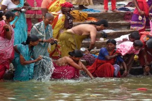 Sulle gradinate degradanti che permettono l'accesso all'enorme piscina alimentata dal lago di Saundatti, i pellegrini (prevalentemente donne) si bagnano mediante le piccole anfore d'argento con cui raccolgono l'acqua da versare sui loro corpi, lavano le vesti, lasciano offerte alla Dea Yallamma, abbandonano le loro cose vecchie. Colori di ogni gradazione e di diverse tonalità riempiono il mio sguardo come se stessi ammirando una tela sapientemente dipinta. Tutti appaiono allegri e cordiali, si respirano elevate vibrazioni positive, tutto intorno è un fremito di esaltazione della bellezza, della purificazione, della rinascita. Il bagno purificatore è necessario per permettere l'accesso dei pellegrini al Tempio della Divinità. Dintorni del villaggio di Saundatti, Regione del Karnataka, India 2015.