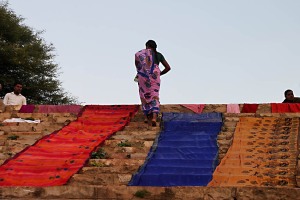 Lungo le scalinate degradanti della grande piscina alimentata dal Saundatti Lake si stendono ad asciugare i sari sul calare della sera, quando la maggior parte dei pellegrini si è ritirata nell'accampamento situato intorno alla collina denominata "Yallammagudda", sulla cui sommità sorge il Tempio Yallamma Devi, dedicato alla Dea Yallamma. Regione del Karnataka, India 2015.