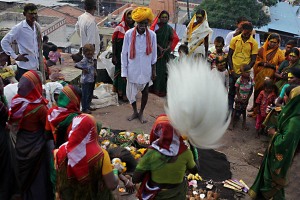 Nell'accampamento insediatosi alle porte del piccolo villaggio di Saundatti in occasione dei festeggiamenti in onore della Dea Yallamma, occupato da oltre centomila pellegrini, anche all'imbrunire si celebrano cerimonie di preghiera, di invocazione e di canti propiziatori in onore della Divinità: qui alcune famiglie hanno creato un cerchio per offrire i doni alla Dea (frutta, fiori, incensi, cibo), invocarla con il ritmo quasi ossessivo della supplica "Udho udho" (il saluto devoto), pregare e servire la Divinità mediante la "Choura", un oggetto simile ad un ventaglio con l'impugnatura in argento (realizzato con capelli umani) con cui sventolano l'immagine della Dea allontanando nel contempo mosche ed insetti. Regione del Karnataka, India 2015.