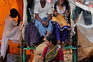 Tutti i partecipanti alla Festa per il Renuka Yallamma Jatra, dedicata alla Dea Yallamma, sono allegri e cordiali: qui una famiglia (composta da padre, madre e figlia) mi sorridono mentre li ritraggo sul loro carro. Le vibrazioni positive generate dalla fede, dalla spiritualità e dalle emozioni si percepiscono nell'aria e sul volto dei pellegrini presenti a questo evento. Accampamento nei dintorni della collina Yallammagudda, villaggio di Saundatti, Regione del Karnataka, India 2015.