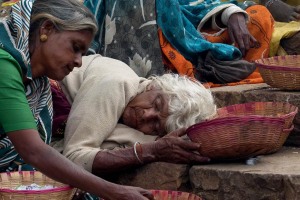 Una anziana donna Dalit (una "Intoccabile") si è addormentata sul gradino dove chiede l'elemosina: prima di addormentarsi, però, ha pensato bene di porre tutte le monete raccolte dai pellegrini sotto il suo cesto che regge con la mano. Un particolare che non mi è sfuggito. Dintorni del Tempio dedicato alla Dea Yallamma, villaggio di Saundatti, Regione del Karnataka, India 2015.