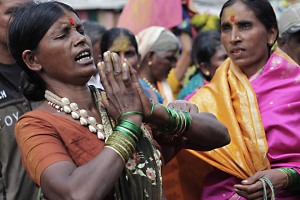 L'invocazione di una "Devadasi", una donna posseduta dallo spirito della Dea Yallamma e per questo considerata il tramite della Divinità sulla terra: il termine Devadasi significa "serva di Dio", in realtà sono giovani donne che vengono fatte sposare (in senso metaforico) alla Divinità del Tempio. Sono bambine che provengono dalle regioni più povere dell'India e sono destinate dai loro stessi genitori a divenire Devadasi. Secondo la tradizione erano originariamente addestrate alla preghiera, alla danza ed alla musica, potevano benedire e togliere il malocchio: in definitiva venivano considerate delle ancelle di Dio consacrate e sposate alla Dea Yallamma, madre dell'Universo, Dea della fertilità, Divinità protettrice dei più umili, dei Popoli tribali, dei contadini, delle prostitute, degli eunuchi e dei transessuali. Ma ormai da tempo le cose sono cambiate: durante il plenilunio queste fanciulle vengono "iniziate" attraverso un rito sessuale ad opera di un sacerdote o patrono del tempio, perdendo la loro verginità. Da questo momento imparano il mestiere di cortigiana, divenendo una importante fonte di reddito per la famiglia di origine. Il turpe commercio dei loro corpi viene in un certo senso giustificato dal presunto "dovere" verso la Divinità: in realtà sono bambine appartenenti alle caste più povere che vengono offerte alle potenti caste sacerdotali dei Brahamani ed ai ricchi dignitari mecenati del tempio. Dintorni del Tempio dedicato alla Dea Yallamma, villaggio di Saundatti, Regione del Karnataka, India 2015.