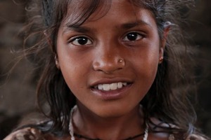 Ritratto di Hemangi, una bambina solare Hindu che, con i genitori, è giunta sino al villaggio di Saundatti per partecipare ai festeggiamenti in onore della Dea Yallamma, la Dea della fertilità protettrice dei tribali, dei contadini, dei più umili, delle Devadasi, degli eunuchi e dei transessuali, conosciuta anche come Jagadamba, la Madre dell'Universo. Regione del Karnataka, India 2015.