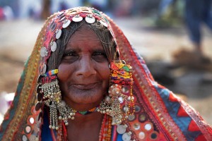 Ritratto di Chitragandha, una donna appartenente all'etnia nomade Banjara nel mercato di Saundatti in occasione dei festeggiamenti dedicati alla Dea Yallamma: questa tribù transumante che ha uno stile di vita errante viene considerata diretta discendente degli antenati indiani dei Rom europei. Da notare il vistoso abbigliamento tradizionale, le numerose collane ed i tradizionali orecchini di varia fattura. Regione del Karnataka, India 2015.