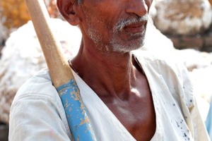 Balraj, operaio della Sha Shivalal Jawaharlal Jain, attende il suo turno per sorreggere e sollevare la balla di cotone con la sua pertica sul camion, dintorni del villaggio di Saundatti, Regione del Karnataka, India 2015.