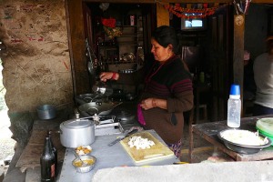 Donne appartenenti all'etnia Gurung cuociono le frittelle nel cortile esterno alla loro abitazione, villaggio di Ghandruk, Nepal 2018.