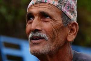 Un anziano uomo nepalese di etnia Gurung (i cui membri si definiscono "Tamu", cioè gli abitanti degli altopiani) con il suo tradizionale cappello "Topi", simbolo di orgoglio e di identità nazionale, svolge la sua "Puja" quotidiana dinanzi ad un tempio (Puja, la preghiera rituale significa "ciò che sconfigge il peccato" e consiste in un atto di adorazione diretto ad una Divinità che si può eprimere mediante un'offerta, una cerimonia o un rito): la sua concentrazione e le sue invocazioni appaiono profondamente autentiche, Villaggio di Pachabbaiya, Nepal 2018.