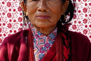 Su mia garbata richiesta questa donna Gurung toglie il copricapo che indossava per mostrare in modo più evidente il "Bindi" rosso che è posto sulla sua fronte: questo segno rosso tondo posto al centro della fronte tra i due occhi in sanscrito significa "goccia", ogni donna di religione Hindu lo applicava quotidianamente a simboleggiare il terzo occhio (o punto di raccoglimento energetico) ma, nel corso del tempo, il senso mistico è andato perduto per far strada ad una tendenza estetica e decorativa. Lungolago di Phewa Tal, Pokhara, Nepal 2018.