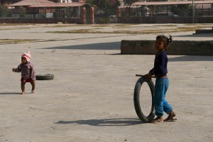 Nel piazzale antistante l'ingresso del complesso di Pashupatinath, due bambini nepalesi appartenenti all'etnia Gurung giocano con due vecchi copertoni di motociclette: il più piccolo si chiama Kamal, la più grande Sabriti ed hanno, rispettivamente, due e 10 anni. Nepal 2018.