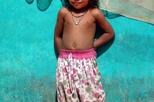 "Ravi" (in sanscrito significa "sole") è una bambina Kodavas di 5 anni: di fronte all'obiettivo della mia macchina appare un pochino imbarazzata. Pur essendo così piccola indossa una coppia di eleganti cavigliere e due collane portafortuna.Villaggio di Kakkabe, Distretto di Kodagu, Regione del Karnataka, India 2015.