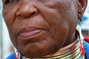 Esther Mahalangu, artista internazionale, rappresenta le tradizioni del Popolo Ndebele ai più alti livelli. La fascia di perline che le cinge la fronte, gli anelli tribali in rame ("Idzilla") che indossa sul collo (il primo anello viene donato dal marito al momento del matrimonio, gli anelli successivi vengono aggiunti come pegno d'amore e di fedeltà da parte del compagno e intendono simboleggiare la stima che egli nutre nei confronti della sua donna; più anelli possiede una donna, maggiore è la sua posizione sociale all'interno della tribù. Gli anelli non sono sigillati ma non vengono rimossi neppure quando la donna dorme. Possono essere eliminati solamente quando il consorte muore. Essi non provocano danni permanenti o deformità nel corpo della donna che li indossa. Creano l'illusione di un collo più lungo e aggraziato, considerato molto attraente per gli uomini Ndebele), il "isiphephetu" un grembiule di perline donato dalla madre; gli "isigolwani" spessi cerchi di perline portati al collo, braccia, gambe e vita; un grembiule di pelle indurita che è riccamente decorata con disegni geometrici; una coperta a strisce multicolori molto vivaci