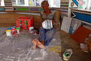 Uomo di etnia Ndbele pratica gli insegnamenti delle proprie donne decorando i vasi di ceramica con antichissime tecniche tramandate di generazione in generazione, Regione Mpulamanga, Villaggio Botshabelo, Sud Africa 2012