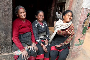 Donne Newari si divertono osservando dei bambini che giocano davanti a loro, dintorni del Palazzo Reale di Patan, Nepal 2018