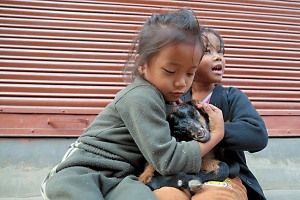 Due bambine Newari giocano con una capretta come se fosse una bambola, Bandipur, Nepal 2018