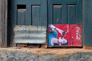 L'ingresso di una antica abitazione Newari, l'ingegnosità degli artigiani sono evidenti: bastano una lamiera ed un cartello pubblicitario per riparare una porta. Bandipur, Nepal 2018