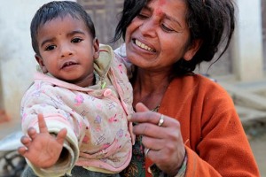 Una donna nepalese di etnia Newari tiene in braccio il suo nipotino (leggermente irrequieto) passeggiando per le stradine del villaggio di Bandipur, Nepal 2018.