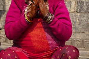 Seduta fuori del Tempio di Siddhi Lakshmi (realizzato in pietra nel XVII secolo), questa donna Newari prega seduta sugli scalini, Bhaktapur, Nepal 2018.