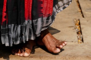 Primo piano dei piedi scalzi di un'anziana donna appartenente all'etnia Newari che non intendeva assolutamente essere fotografata: i suoi piedi raccontano la sua esistenza travagliata fatta di fatica e di privazioni, Villaggio di Pharping, Nepal 2018.