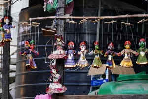 Nel villaggio Newari di Kirtipur, accanto ad un serbatoio d'acqua, sono state appese ad asciugare queste marionette realizzate artigianalmente: da notare l'attenzione destinata ai particolari e la raffinata esecuzione, dei veri piccoli gioielli. Nepal 2018.