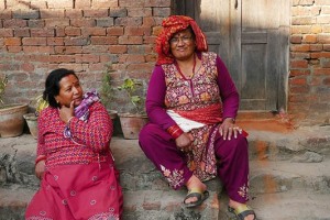 Due donne Newari con i tipici vestiti tradizionali chiaccherano amabilmente sull'uscio delle loro abitazioni, villaggio di Kirtipur, Nepal 2018.
