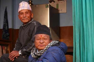 Due uomini Newari all'interno della loro bottega, in un vicolo accanto al Lohan Dehar, un Tempio Hindu presente nel villaggio di Kirtipur, Nepal 2018.