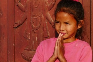 Questa splendida bimba Newari di nome Hira Thapa, mi conduce tra le polverose stradine del villaggio di Kirtipur, a conoscere la sua mamma: sul portone di ingresso unisce il palmo delle mani nel tradizionale saluto "Namastè" (mi inchino alla Divinità che risiede in te, qui sei il benvenuto), Nepal 2018.