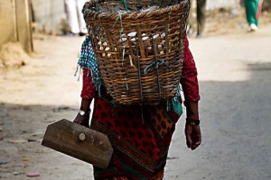 Una donna Newari appartenente alla casta degli agricoltori ("Vaisya") si dirige a casa dopo aver lavorato duramente in campagna con la zappa che tiene in mano: nella cesta ha raccolto qualche ortaggio per la cena. Villaggio di Bhaktapur, Nepal 2018.